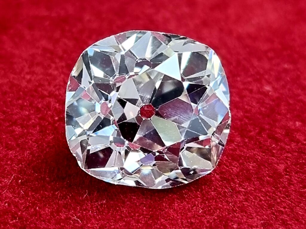 An old mine cut diamond weighing 5 carats on a red background