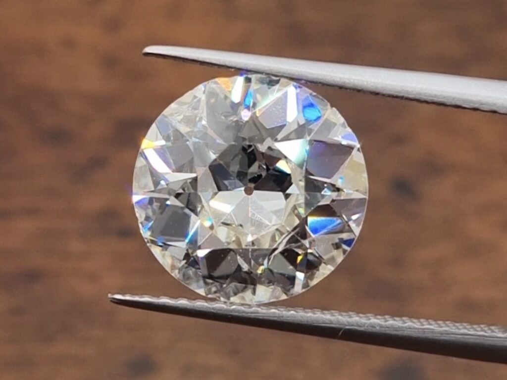 A 4 carat Old European Cut Diamond being held in a tweezer