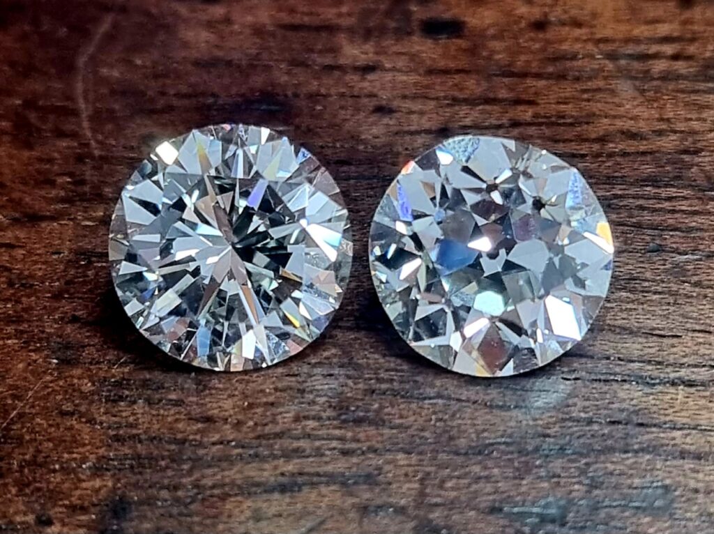 modern round diamond next to old european cut on wooden background