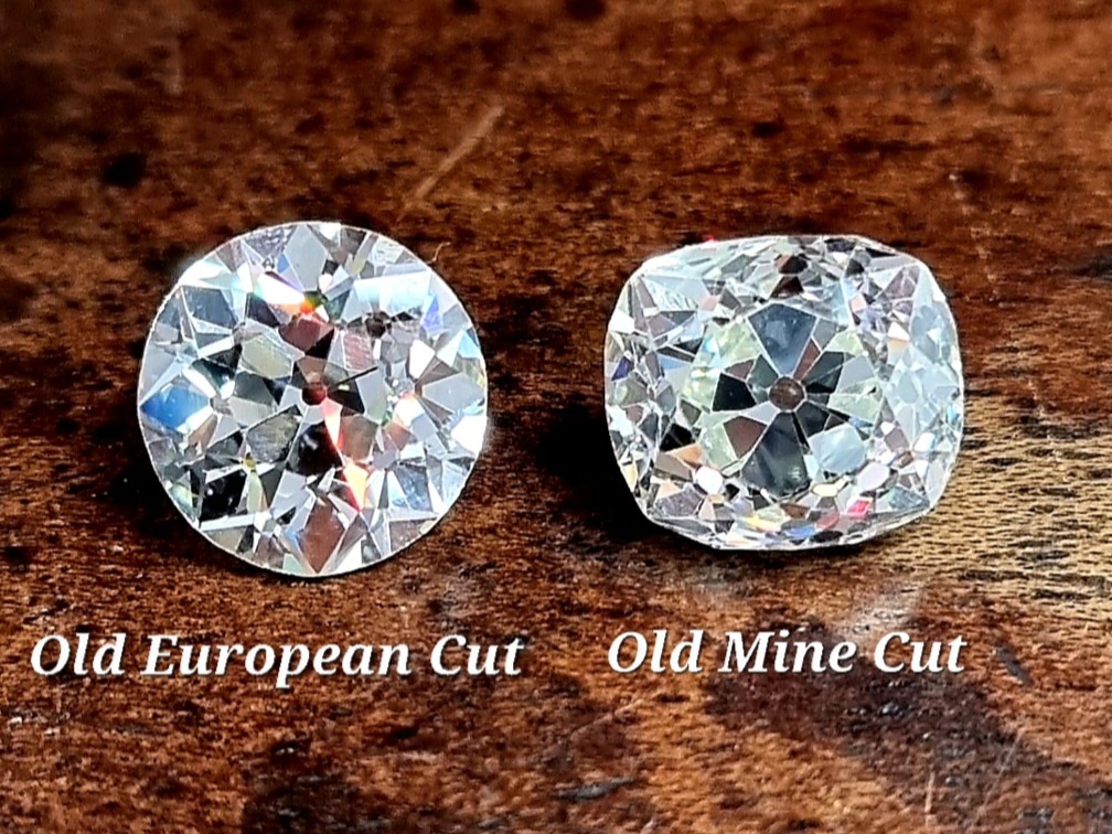 an old european cut diamond next to an old mine cut diamond on a wooden background