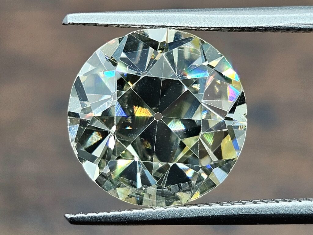 Old European Cut diamond close-up. The stone is held in a tweezer.