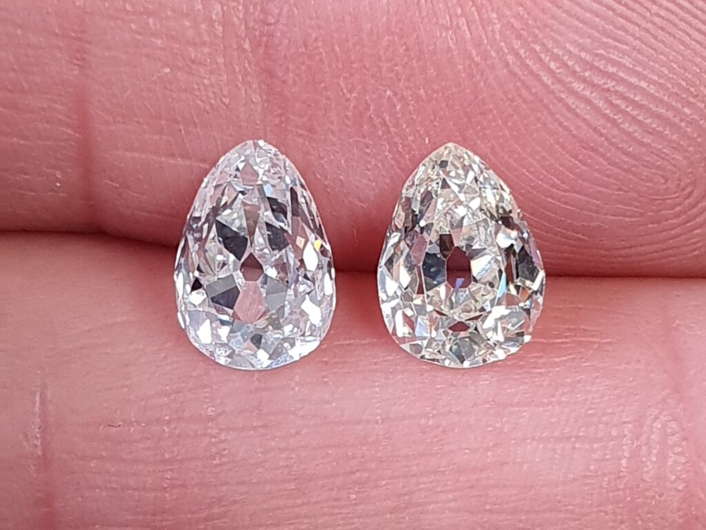 2 antique pear shape diamonds held between fingers