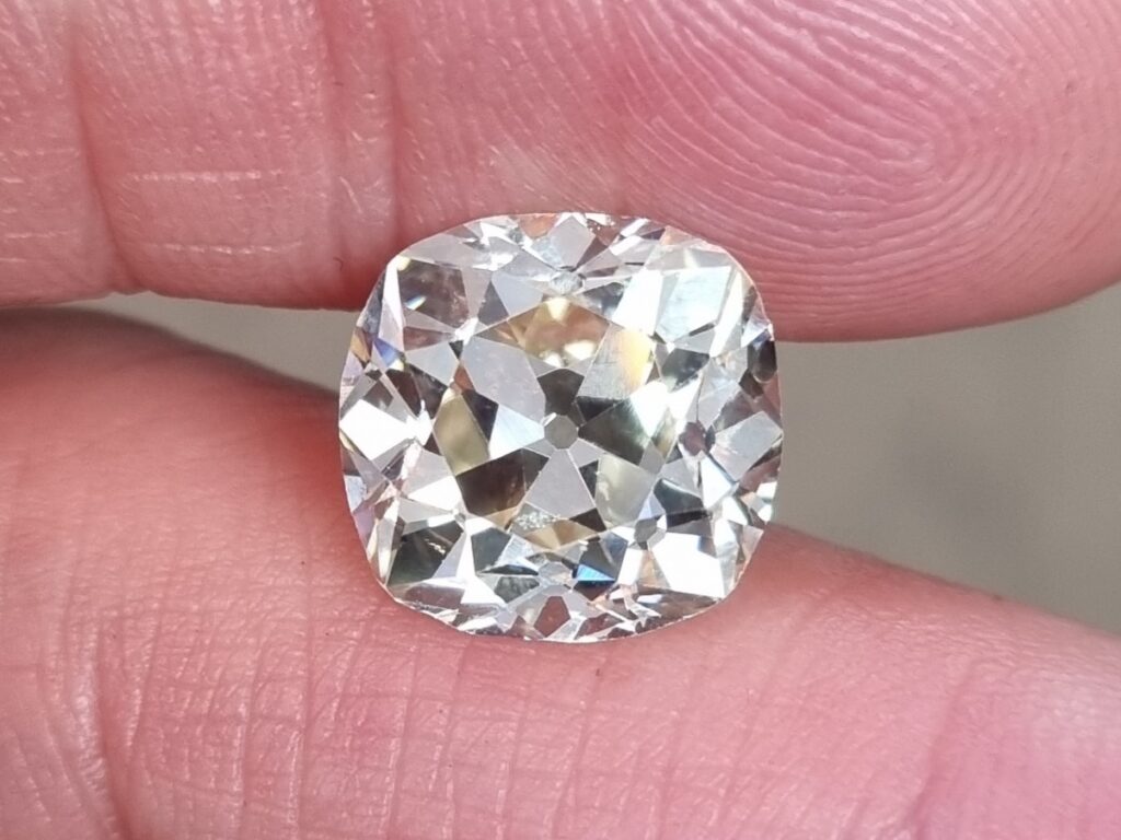 A 10ct old mine cut diamond held between fingers